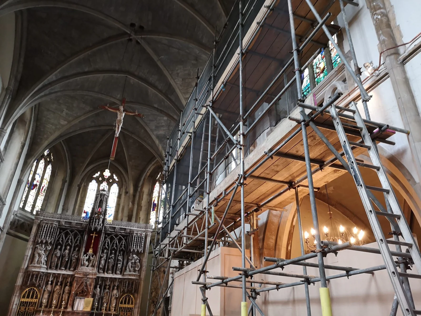 Internal scaffolding in a church nave beside the altar and crucifix