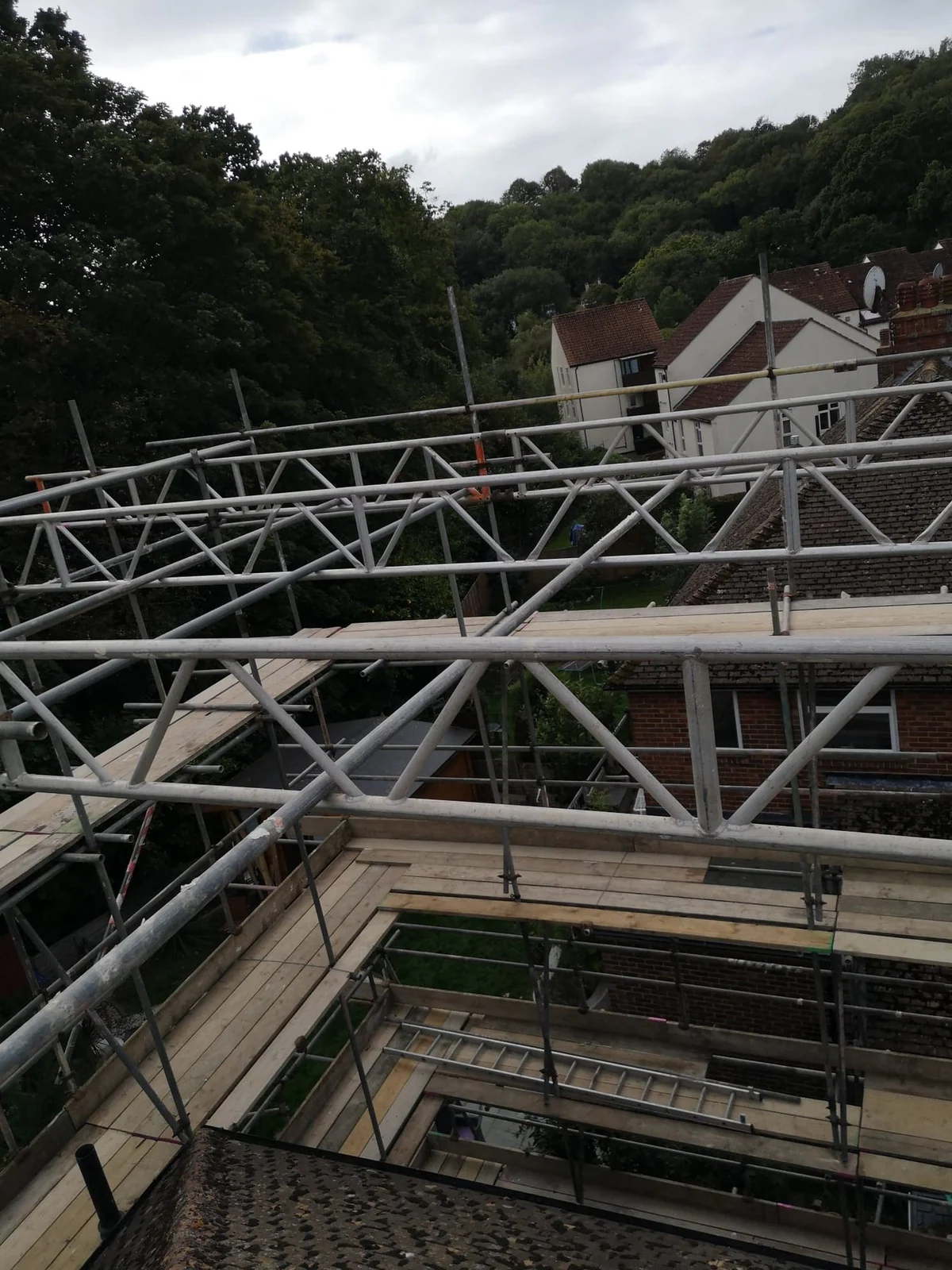 View down through scaffold trusses onto neighbouring roofs